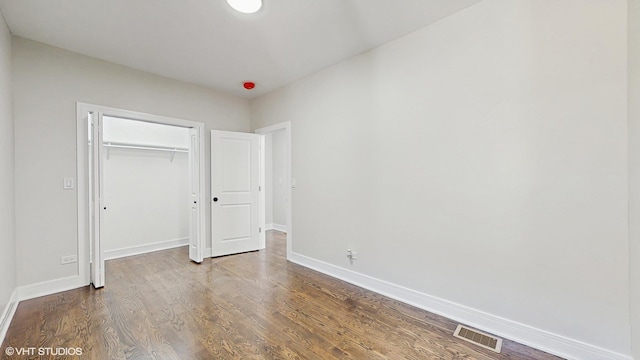 7545 S Perry Ave, Chicago, IL 60620 - unfurnished bedroom with baseboards, a closet, and dark wood-style flooring