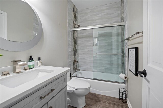 670 Leslie Ct, Carol Stream, IL 60188 - bathroom featuring vanity, toilet, wood finished floors, and shower / bath combination with glass door