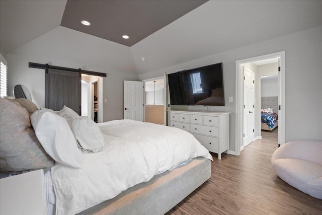 670 Leslie Ct, Carol Stream, IL 60188 - bedroom featuring lofted ceiling, a walk in closet, light wood finished floors, a barn door, and recessed lighting