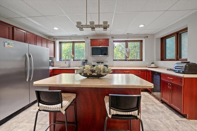 670 Leslie Ct, Carol Stream, IL 60188 - kitchen with freestanding refrigerator, beverage cooler, a sink, a drop ceiling, and a breakfast bar area