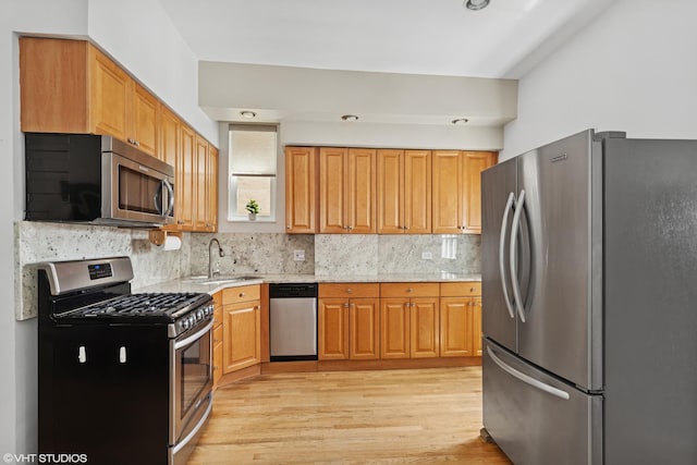 2637 W Huron St, Chicago, IL 60612 - kitchen with stainless steel appliances, a sink, light wood-style floors, and decorative backsplash