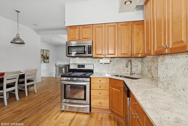 2637 W Huron St, Chicago, IL 60612 - kitchen with stainless steel appliances, a sink, light stone counters, decorative backsplash, and light wood finished floors