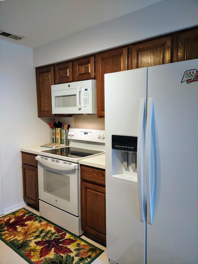 1175 Lake Cook Rd Unit 201W, Northbrook, IL 60062 - kitchen with white appliances, light countertops, and dark brown cabinetry