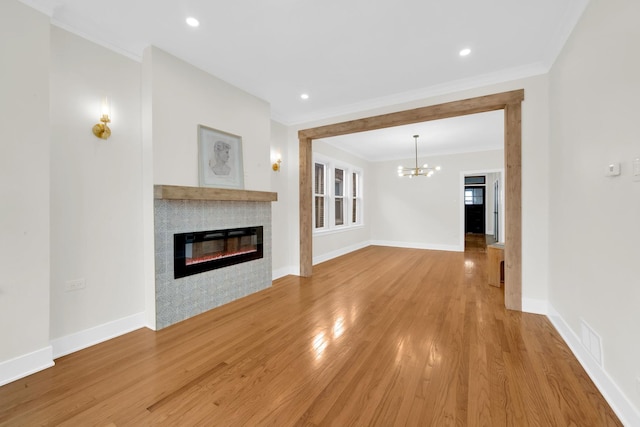 7535 S Aberdeen St, Chicago, IL 60620 - unfurnished living room featuring ornamental molding, a tiled fireplace, a chandelier, light wood-style floors, and baseboards