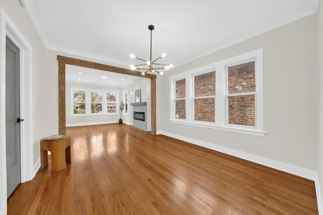 7535 S Aberdeen St, Chicago, IL 60620 - unfurnished living room featuring a chandelier, light wood finished floors, baseboards, crown molding, and a glass covered fireplace