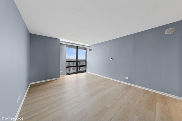 10 E Ontario St Unit 4805, Chicago, IL 60611 - empty room with light wood-style flooring, floor to ceiling windows, and baseboards