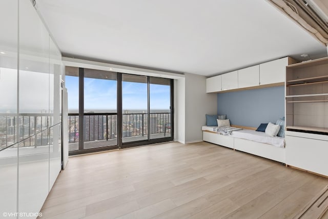 10 E Ontario St Unit 4805, Chicago, IL 60611 - unfurnished living room with floor to ceiling windows, light wood-style flooring, and baseboards