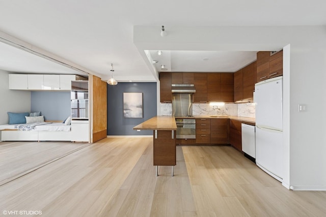 10 E Ontario St Unit 4805, Chicago, IL 60611 - kitchen featuring white appliances, under cabinet range hood, light wood-style floors, decorative backsplash, and brown cabinets