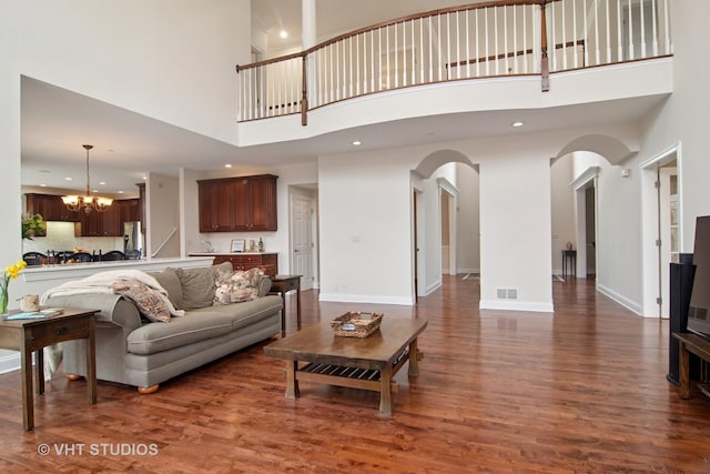 4824 Darlene Ct E, Long Grove, IL 60047 - living area featuring arched walkways, a chandelier, a high ceiling, dark wood-type flooring, and baseboards