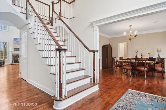 4824 Darlene Ct E, Long Grove, IL 60047 - stairs featuring wood finished floors, a chandelier, arched walkways, a towering ceiling, and crown molding