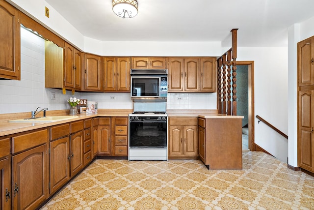 533 Lomond Dr, Mundelein, IL 60060 - kitchen featuring white gas stove, a sink, black microwave, and brown cabinetry