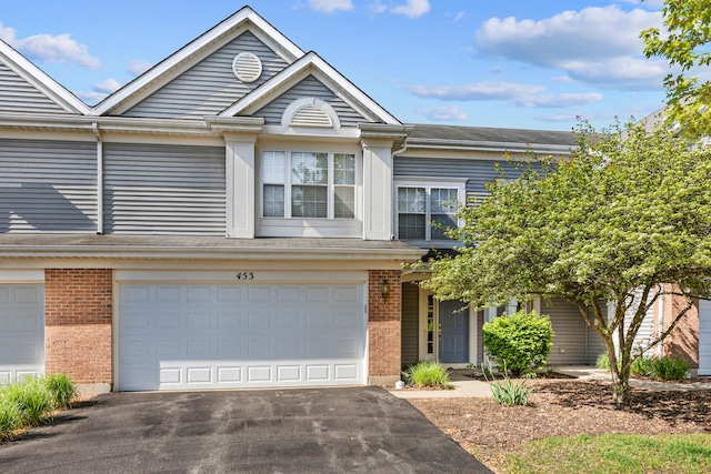 453 Lancaster Dr, Pingree Grove, IL 60140 - view of property featuring brick siding, driveway, and a garage