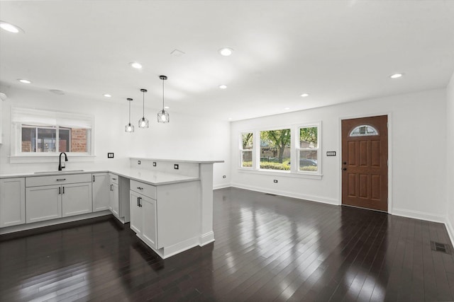 6903 S Ada St, Chicago, IL 60636 - kitchen with a sink, a peninsula, light countertops, dark wood-type flooring, and recessed lighting
