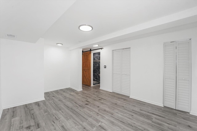 6903 S Ada St, Chicago, IL 60636 - below grade area featuring a barn door, light wood-type flooring, and baseboards