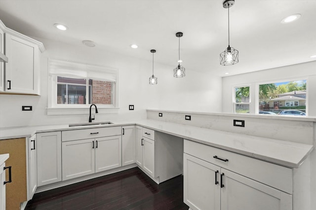 6903 S Ada St, Chicago, IL 60636 - kitchen with a sink, dark wood finished floors, white cabinets, hanging light fixtures, and light stone counters