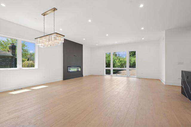 9214 N Washington St, Niles, IL 60714 - unfurnished living room featuring a fireplace, light wood-style flooring, baseboards, recessed lighting, and a chandelier