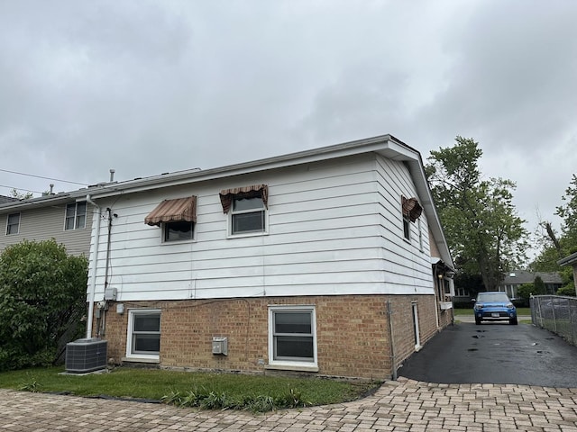 11024 Mason Ave, Chicago Ridge, IL 60415 - view of home's exterior with brick siding, decorative driveway, and central AC unit