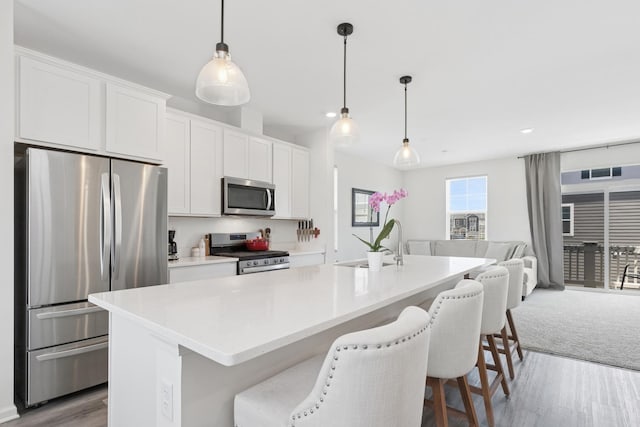 2011 Sequoia Ave, Mundelein, IL 60060 - kitchen with stainless steel appliances, open floor plan, light wood-style floors, white cabinets, and a breakfast bar area