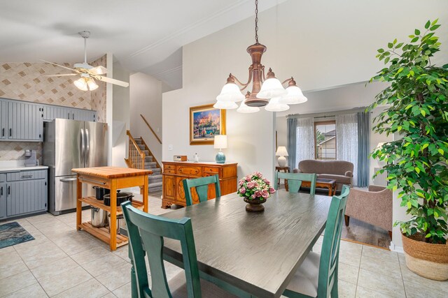 291 Georgetown Ave, Romeoville, IL 60446 - dining area featuring a ceiling fan, high vaulted ceiling, stairs, light tile patterned floors, and a chandelier