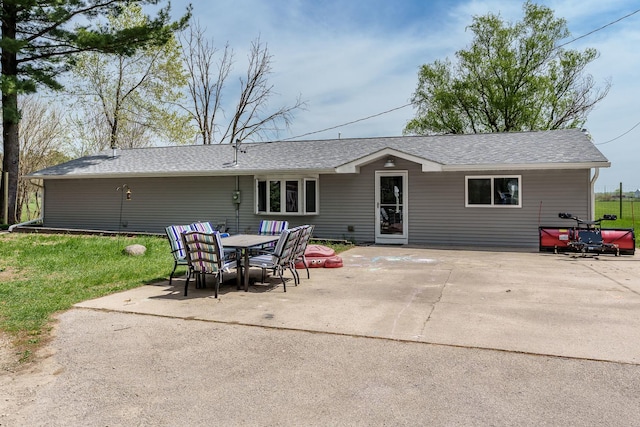 rear view of property with a patio, a yard, and roof with shingles