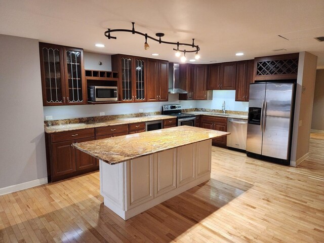 680 N Lake Shore Dr Unit 716, Chicago, IL 60611 - kitchen with stainless steel appliances, wall chimney range hood, light wood-style floors, baseboards, and glass insert cabinets