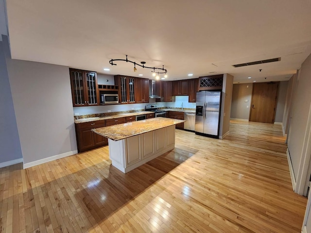 680 N Lake Shore Dr Unit 716, Chicago, IL 60611 - kitchen featuring appliances with stainless steel finishes, light wood-style flooring, wall chimney range hood, baseboards, and glass insert cabinets
