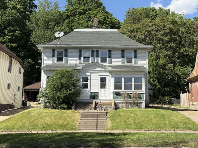 428 Chicago Ave, Savanna, IL 61074 - view of front of home featuring roof with shingles, a front yard, a chimney, and board and batten siding