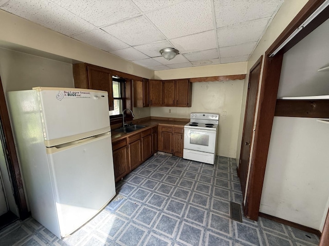 428 Chicago Ave, Savanna, IL 61074 - kitchen featuring white appliances, a sink, a drop ceiling, and tile patterned floors