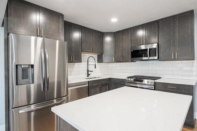 5831 Allemong Dr, Matteson, IL 60443 - kitchen featuring stainless steel appliances, a sink, light countertops, tasteful backsplash, and a kitchen island