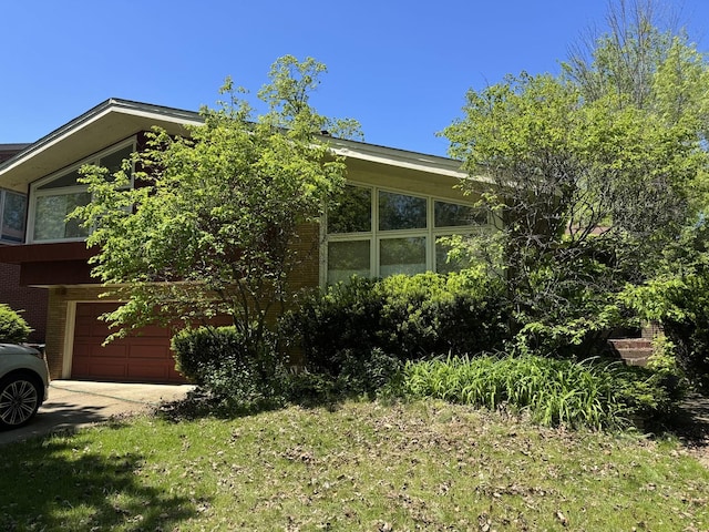 9010 Keeler Ave, Skokie, IL 60076 - view of home's exterior featuring an attached garage, brick siding, driveway, and a sunroom