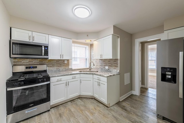 14746 Princeton Ave, Dolton, IL 60419 - kitchen featuring appliances with stainless steel finishes, a sink, decorative backsplash, and light wood finished floors