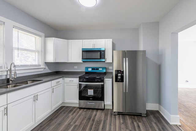 14446 Martin Luther King Jr Dr, Dolton, IL 60419 - kitchen featuring appliances with stainless steel finishes, a sink, dark wood-style floors, dark countertops, and white cabinets
