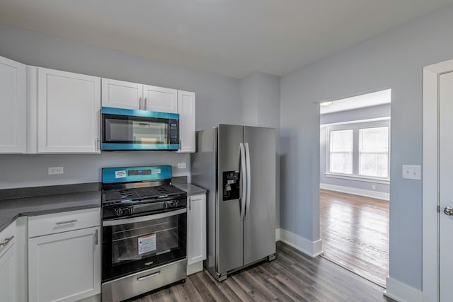 14446 Martin Luther King Jr Dr, Dolton, IL 60419 - kitchen featuring stainless steel appliances, dark countertops, dark wood-style flooring, and white cabinets