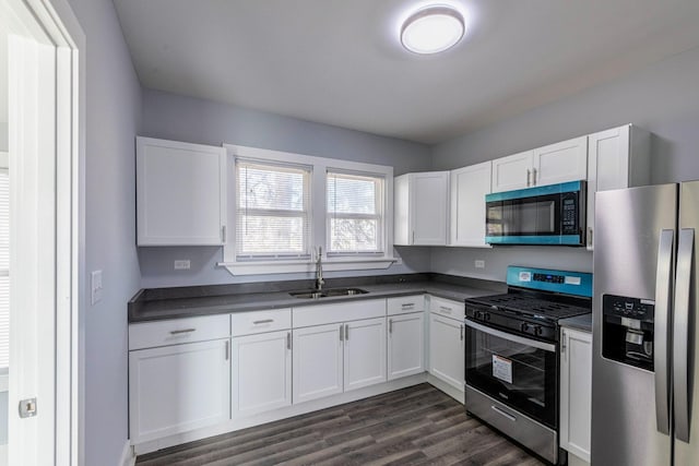 14446 Martin Luther King Jr Dr, Dolton, IL 60419 - kitchen with stainless steel appliances, a sink, dark countertops, and white cabinets
