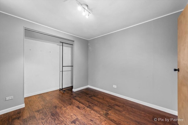 405 S Belmont Ave, Elgin, IL 60123 - unfurnished bedroom with wood finished floors, baseboards, rail lighting, and a closet