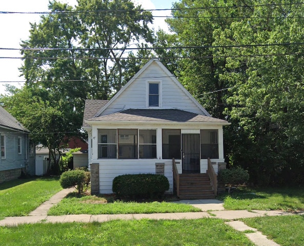 14308 Grant St, Dolton, IL 60419 - bungalow-style house with a sunroom, roof with shingles, and a front yard