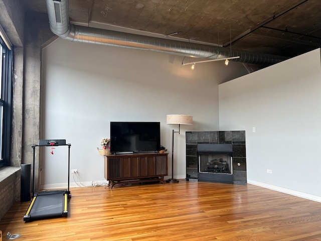 1001 W 15th St Unit 342, Chicago, IL 60608 - unfurnished living room featuring wood finished floors, a high ceiling, a fireplace, and baseboards