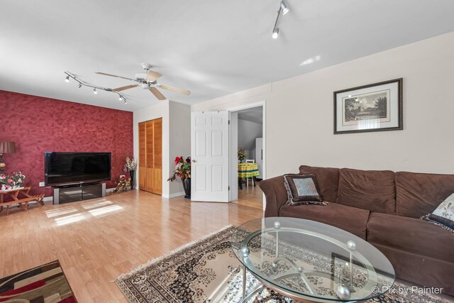 3324 N Ottawa Ave, Chicago, IL 60634 - living room featuring track lighting, a ceiling fan, wood finished floors, an accent wall, and wallpapered walls