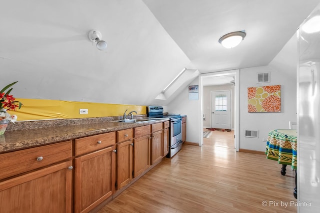 3324 N Ottawa Ave, Chicago, IL 60634 - kitchen with electric stove, light wood-style flooring, brown cabinetry, vaulted ceiling, and dark countertops