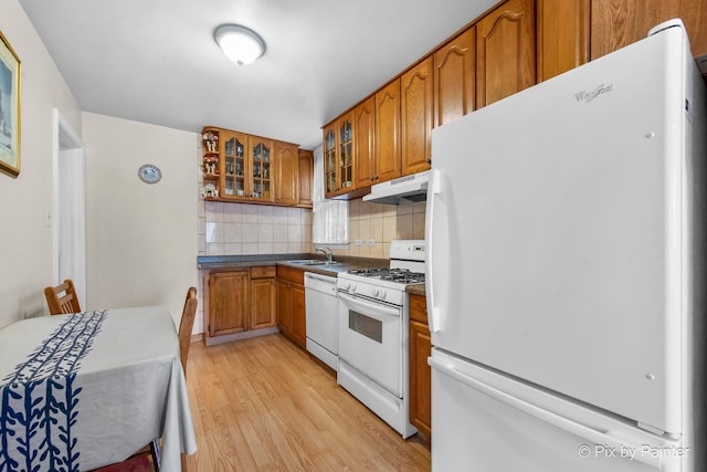 3324 N Ottawa Ave, Chicago, IL 60634 - kitchen featuring white appliances, under cabinet range hood, light wood-style flooring, brown cabinets, and decorative backsplash