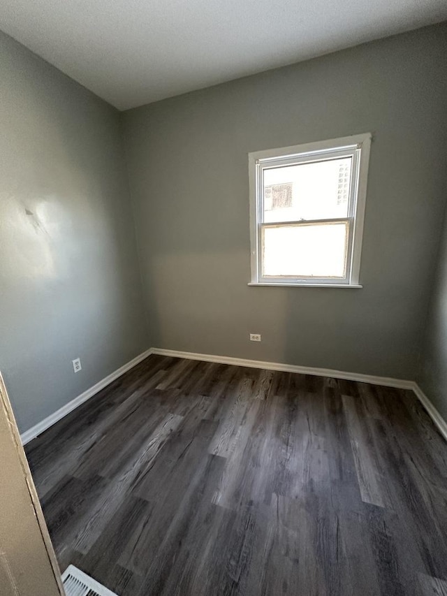 4942 S Racine Ave, Chicago, IL 60609 - spare room with dark wood-style floors and baseboards