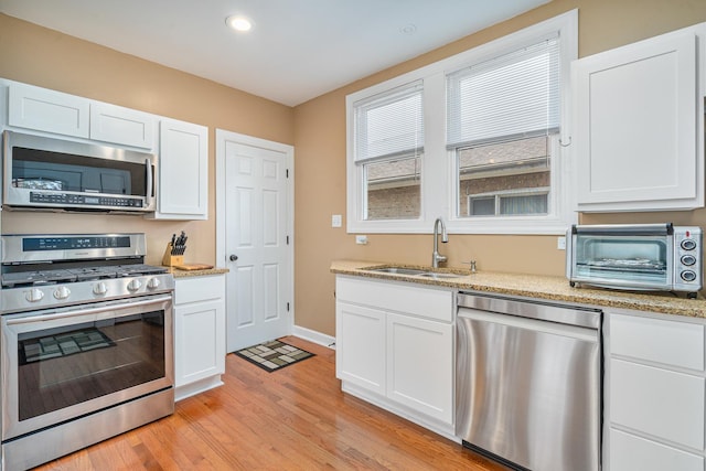 1627 S 14th Ave, Maywood, IL 60153 - kitchen with appliances with stainless steel finishes, white cabinets, light wood-style floors, light stone counters, and recessed lighting