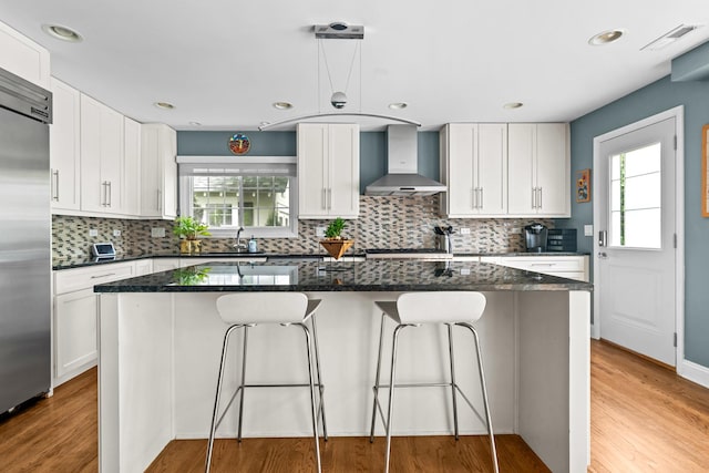 1101 Oak St, Winnetka, IL 60093 - kitchen featuring wall chimney exhaust hood, stainless steel built in refrigerator, plenty of natural light, white cabinetry, and recessed lighting