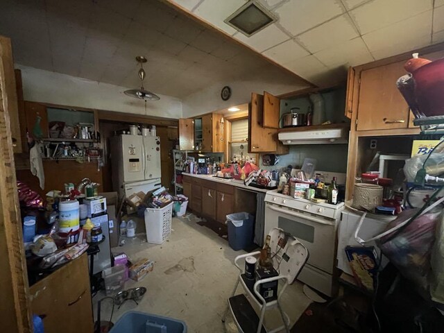 802 Locust St, Prophetstown, IL 61277 - kitchen with white appliances, under cabinet range hood, light countertops, brown cabinetry, and a drop ceiling