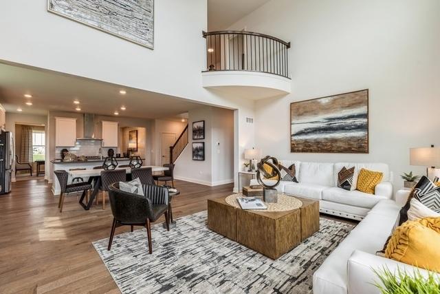 213 Rhinebeck Way, Algonquin, IL 60102 - living room with stairway, wood finished floors, a high ceiling, and baseboards