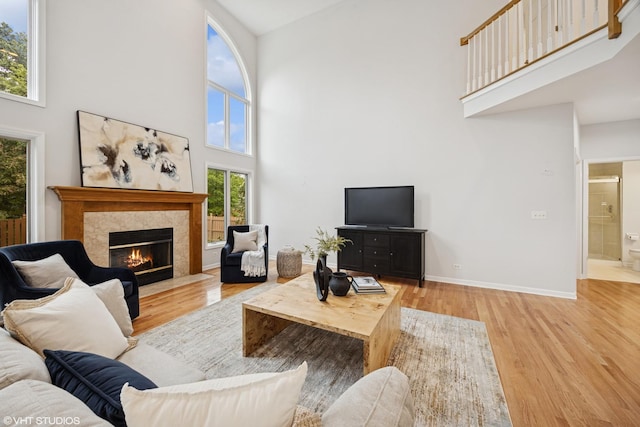 1040 E Buckingham Dr, Naperville, IL 60563 - living area with a towering ceiling, wood finished floors, a tile fireplace, and baseboards
