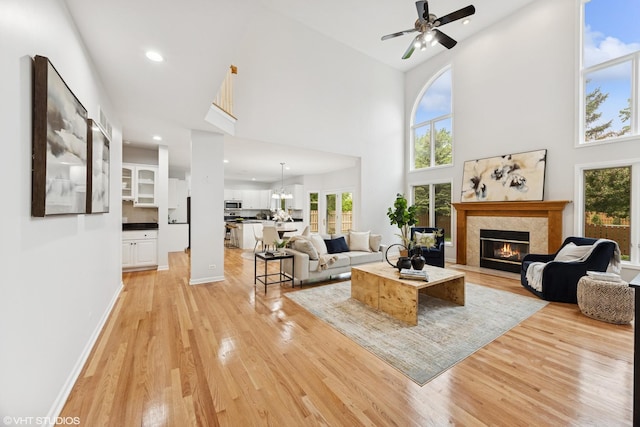 1040 E Buckingham Dr, Naperville, IL 60563 - living room with light wood-style floors, a warm lit fireplace, ceiling fan, healthy amount of natural light, and recessed lighting