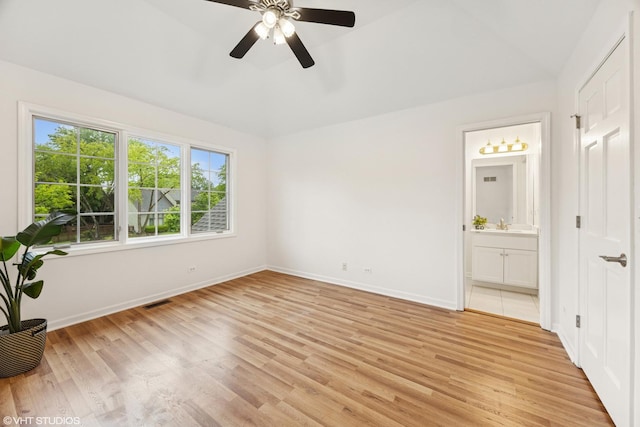 1040 E Buckingham Dr, Naperville, IL 60563 - unfurnished bedroom with light wood-style floors, baseboards, vaulted ceiling, ensuite bath, and ceiling fan
