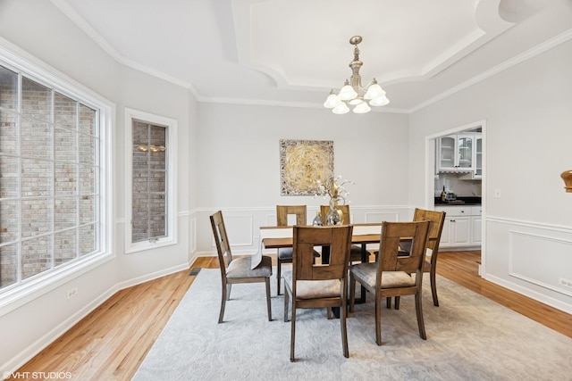 1040 E Buckingham Dr, Naperville, IL 60563 - dining space with a chandelier, light wood-type flooring, a tray ceiling, crown molding, and a wainscoted wall