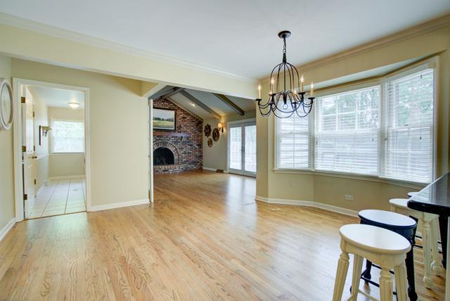 1056 Whirlaway Ave, Naperville, IL 60540 - dining space with a chandelier, plenty of natural light, light wood-style flooring, and a brick fireplace